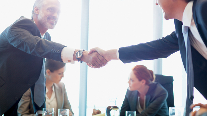Businessmen shaking hands in conference room