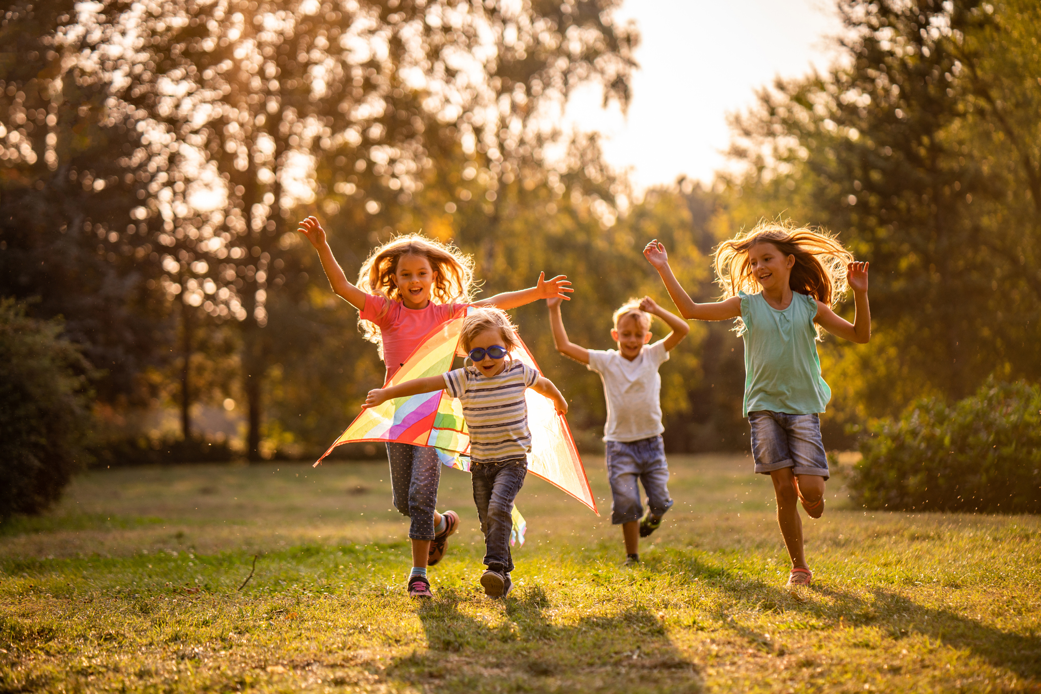 Group of happy children running in public park