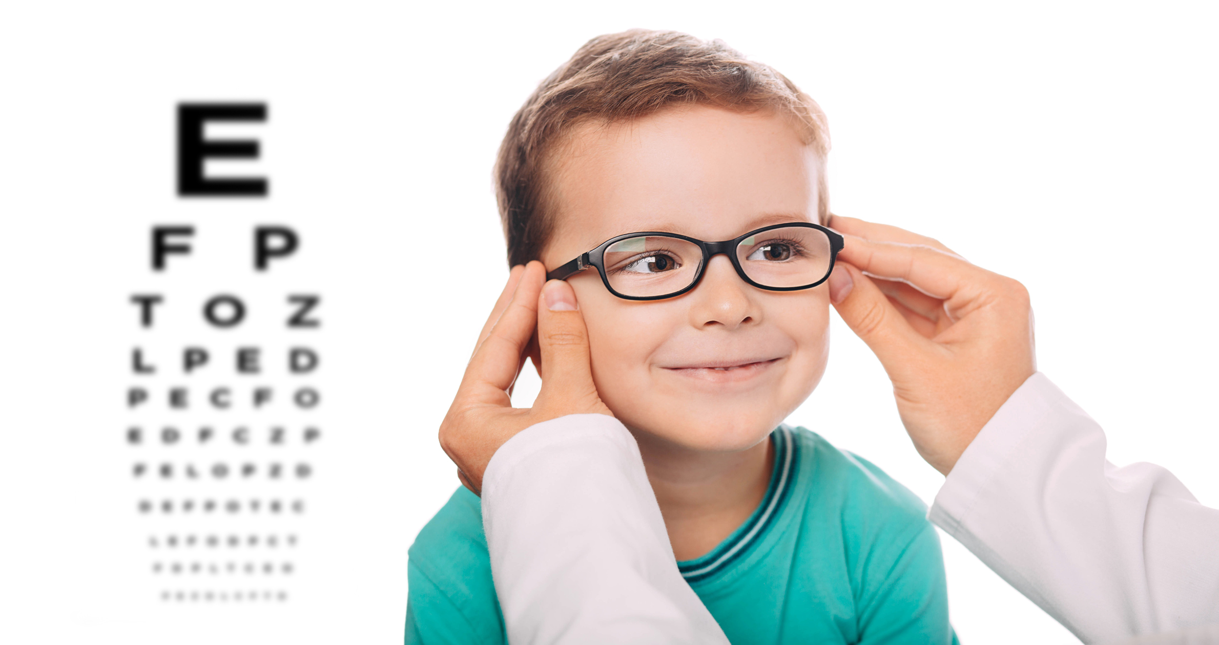 Optometrist is putting new glasses on Little boy face
