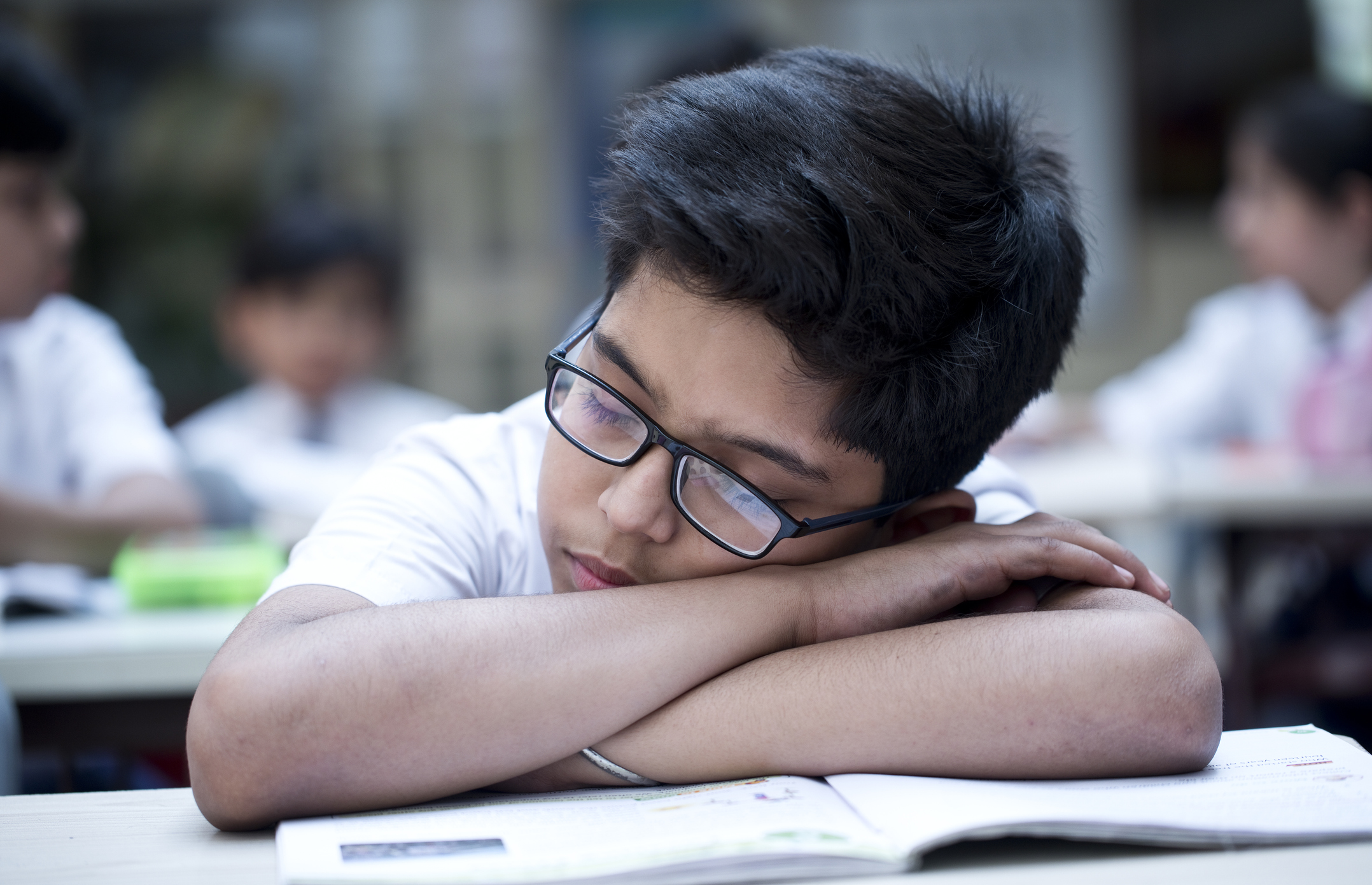 Schoolboy sleeping in classroom