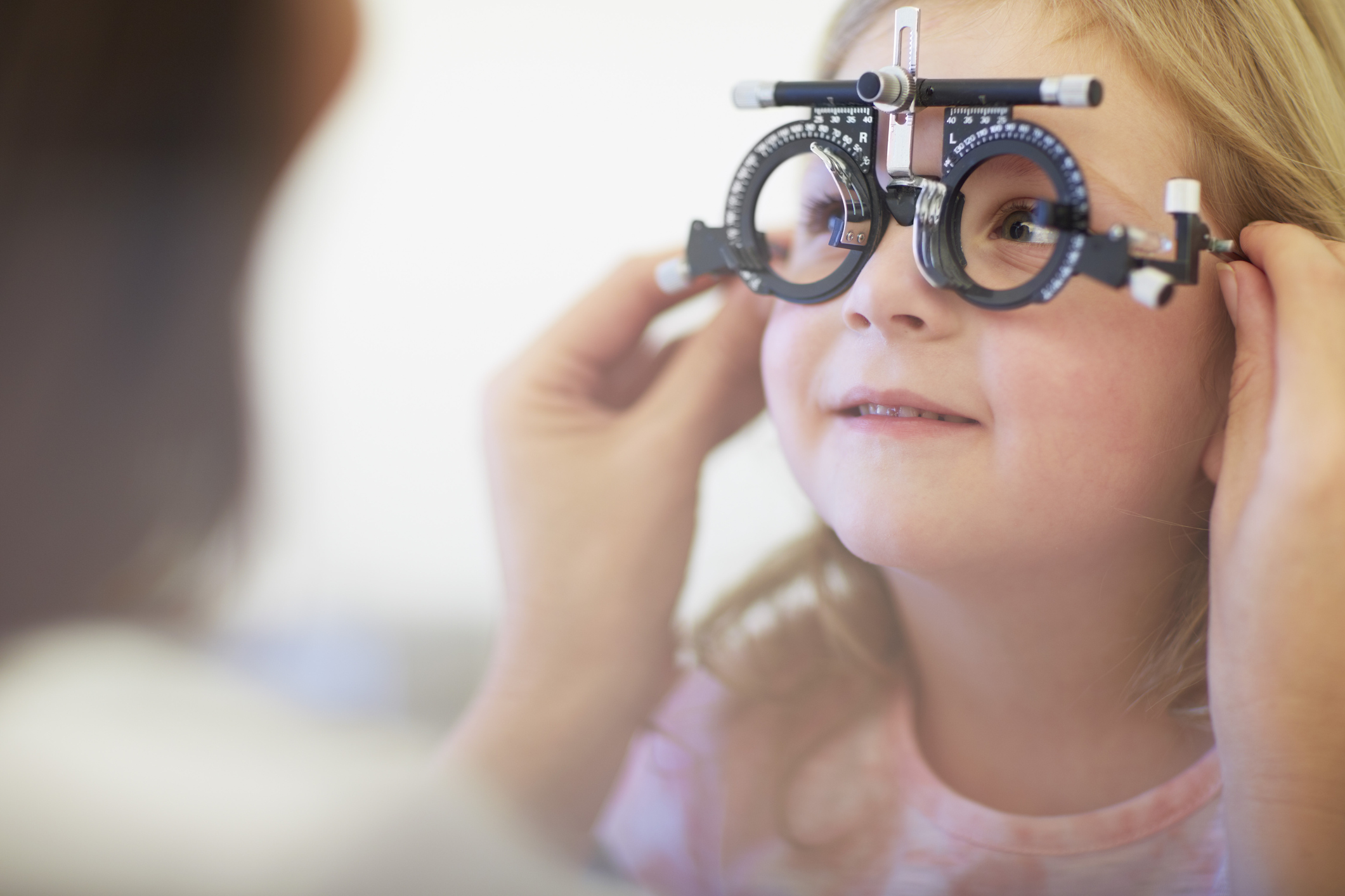 Eye doctor examining girl’s vision