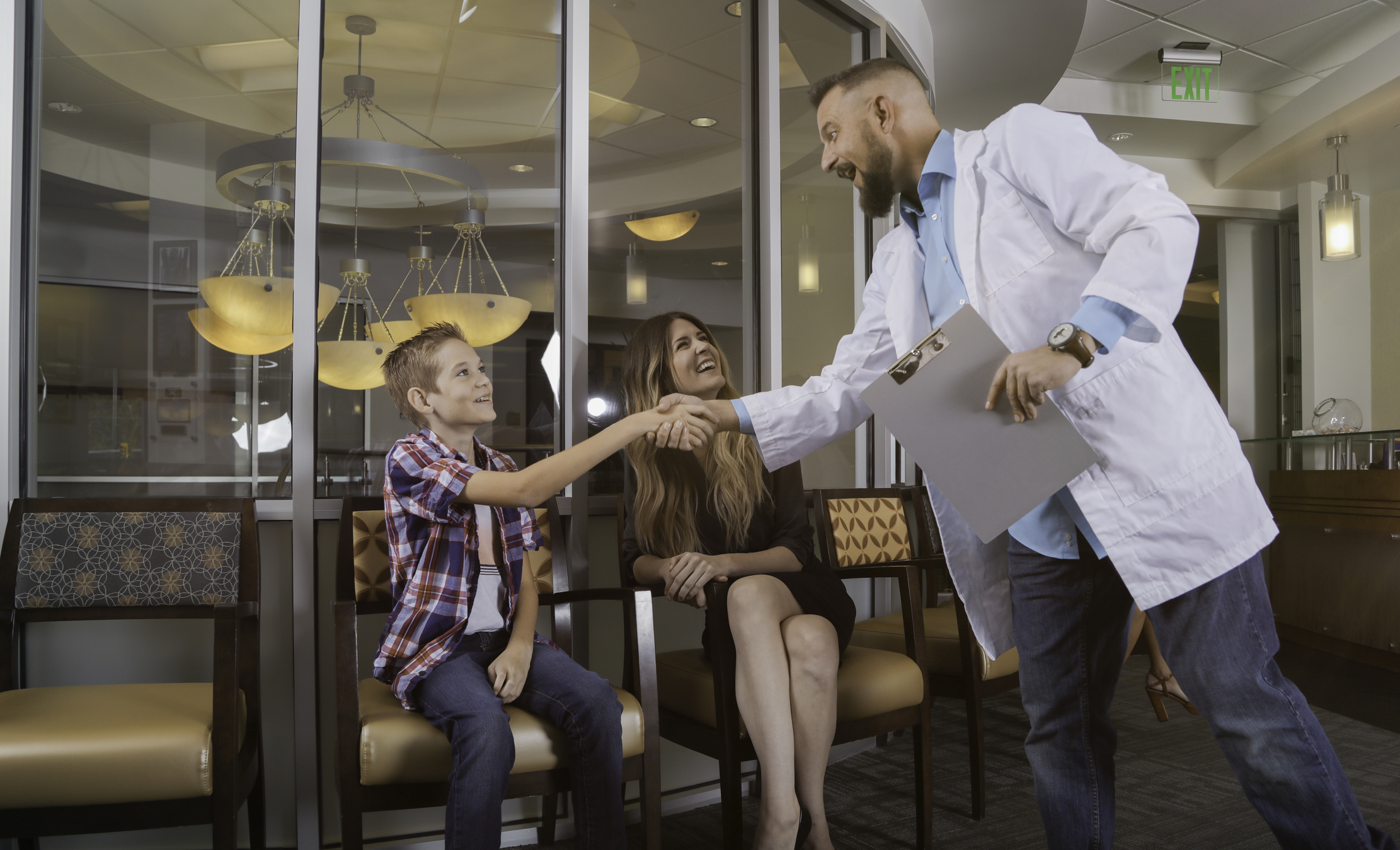 Doctor greeting patients in waiting room with hand shake