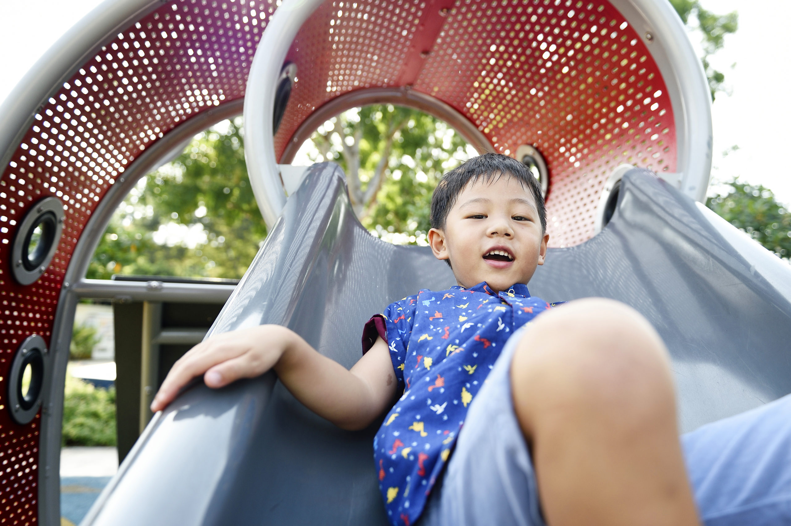 Chinese boy sliding on a playground