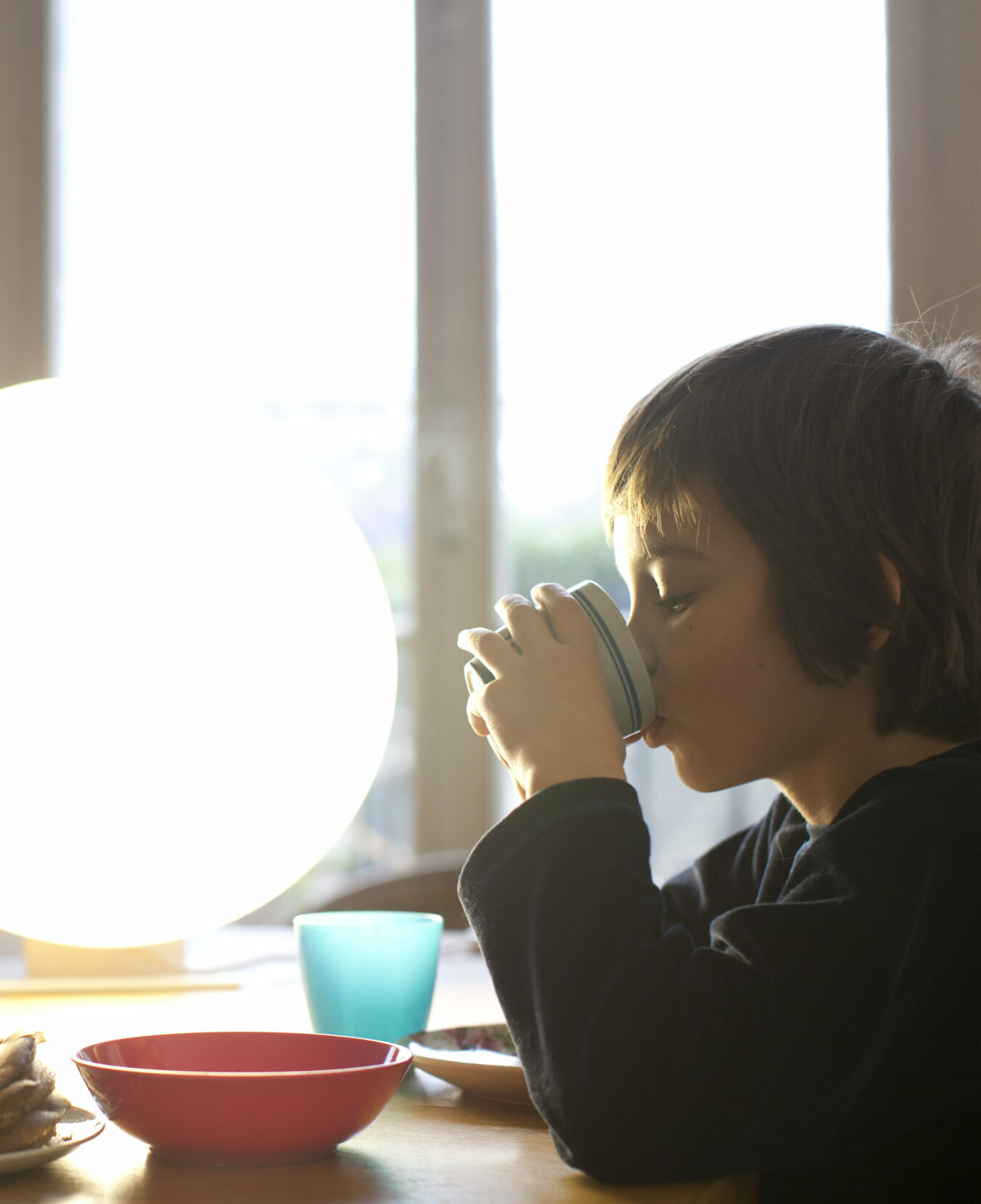 kid having breakfast with light therapy lamp