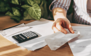 An image of a person looking at bills and a calculator