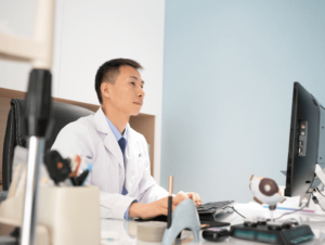 An image of an eye doctor working on a computer