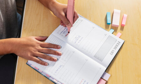 A person's hands color-coding their calendar