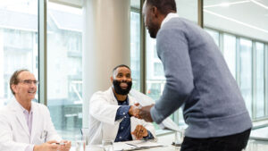 A man shaking hands with a doctor at a job interview